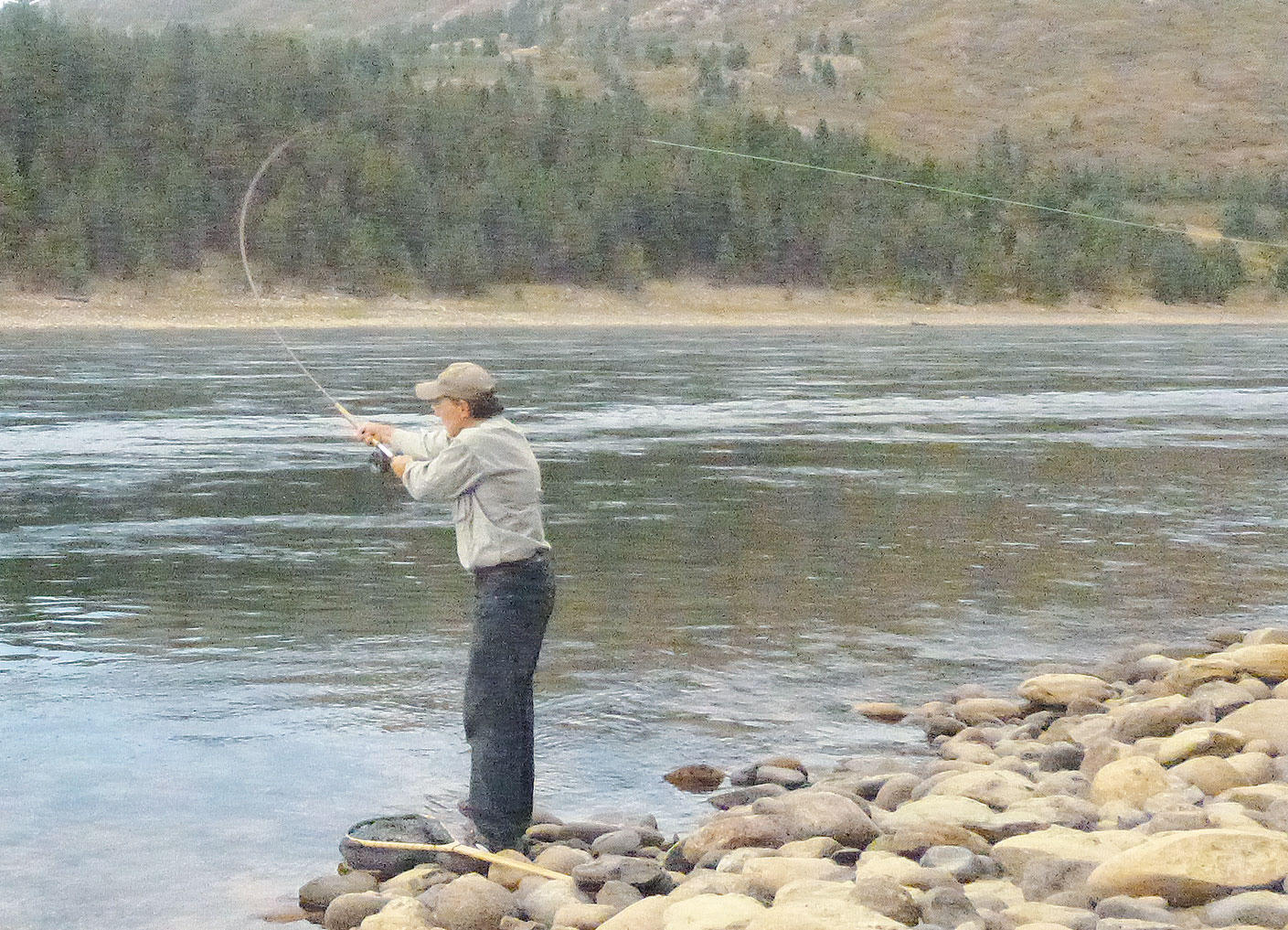 Two-handed cast on a broad river